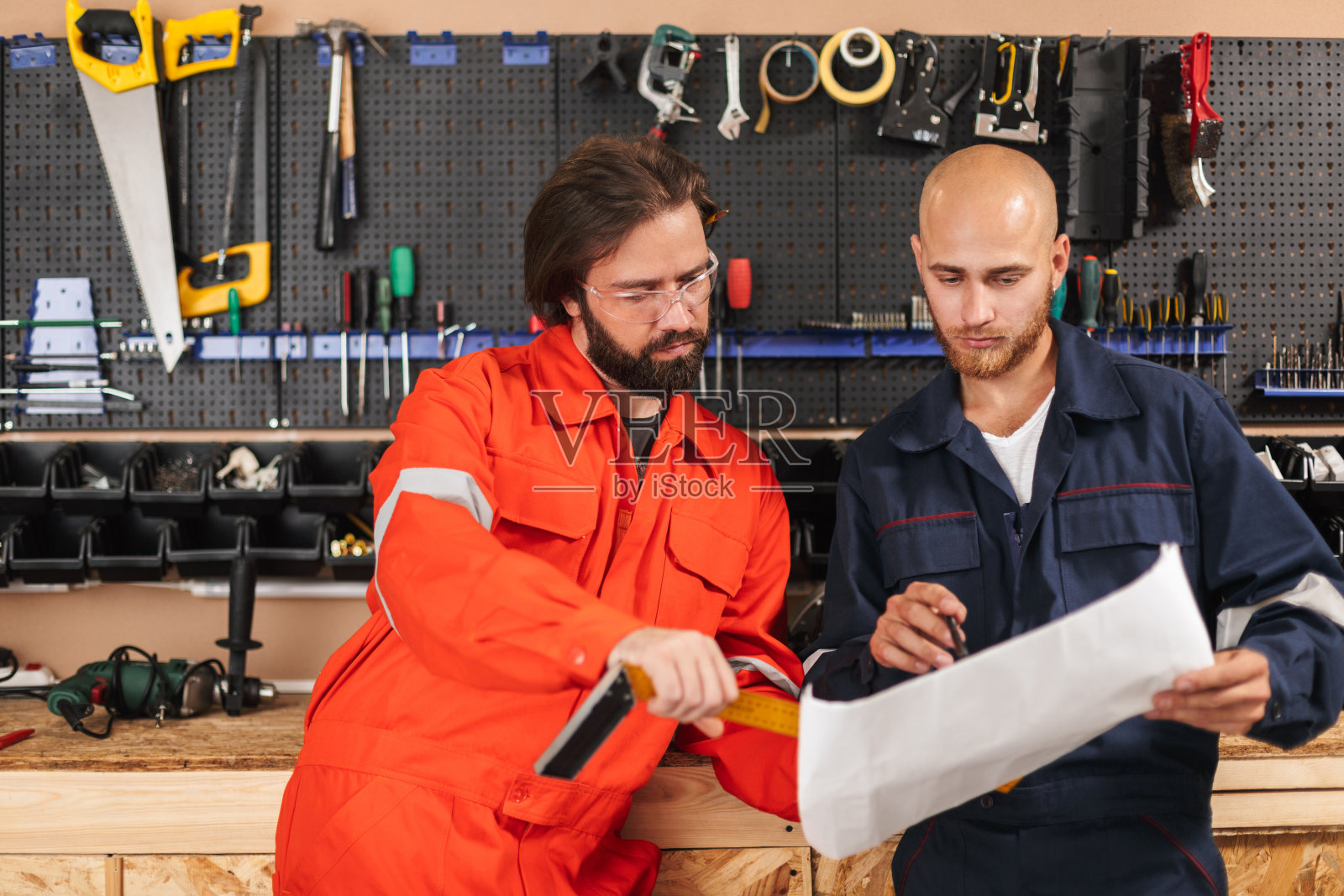 两个穿着工作服的建筑工在认真地画草图照片摄影图片