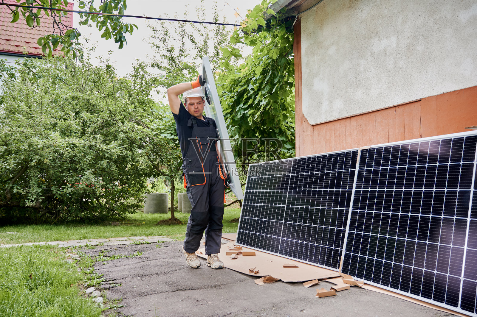 搬运安装太阳能电池板的男性工人照片摄影图片