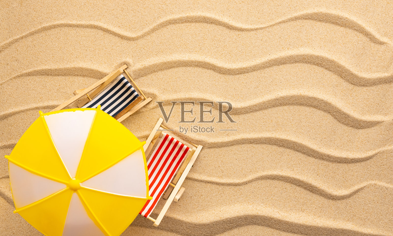 夏天海滩上的概念。黄浪沙滩上的太阳躺椅和太阳伞。海滩的俯视图。照片摄影图片