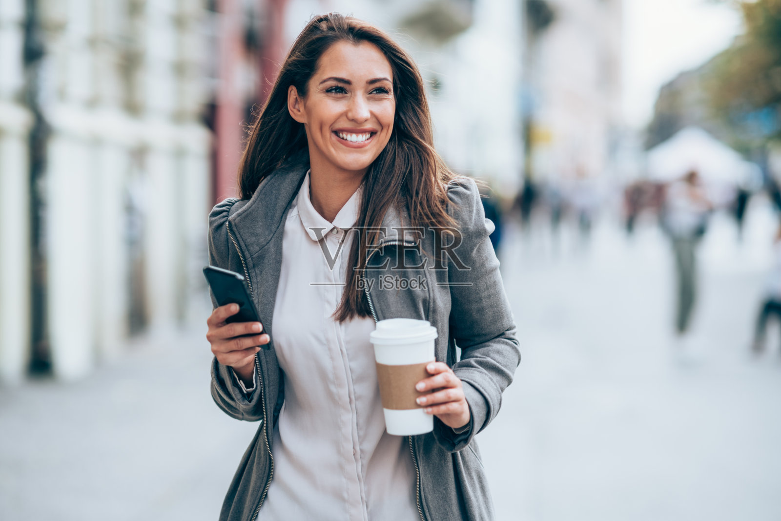 年轻女子在街上使用智能手机。照片摄影图片