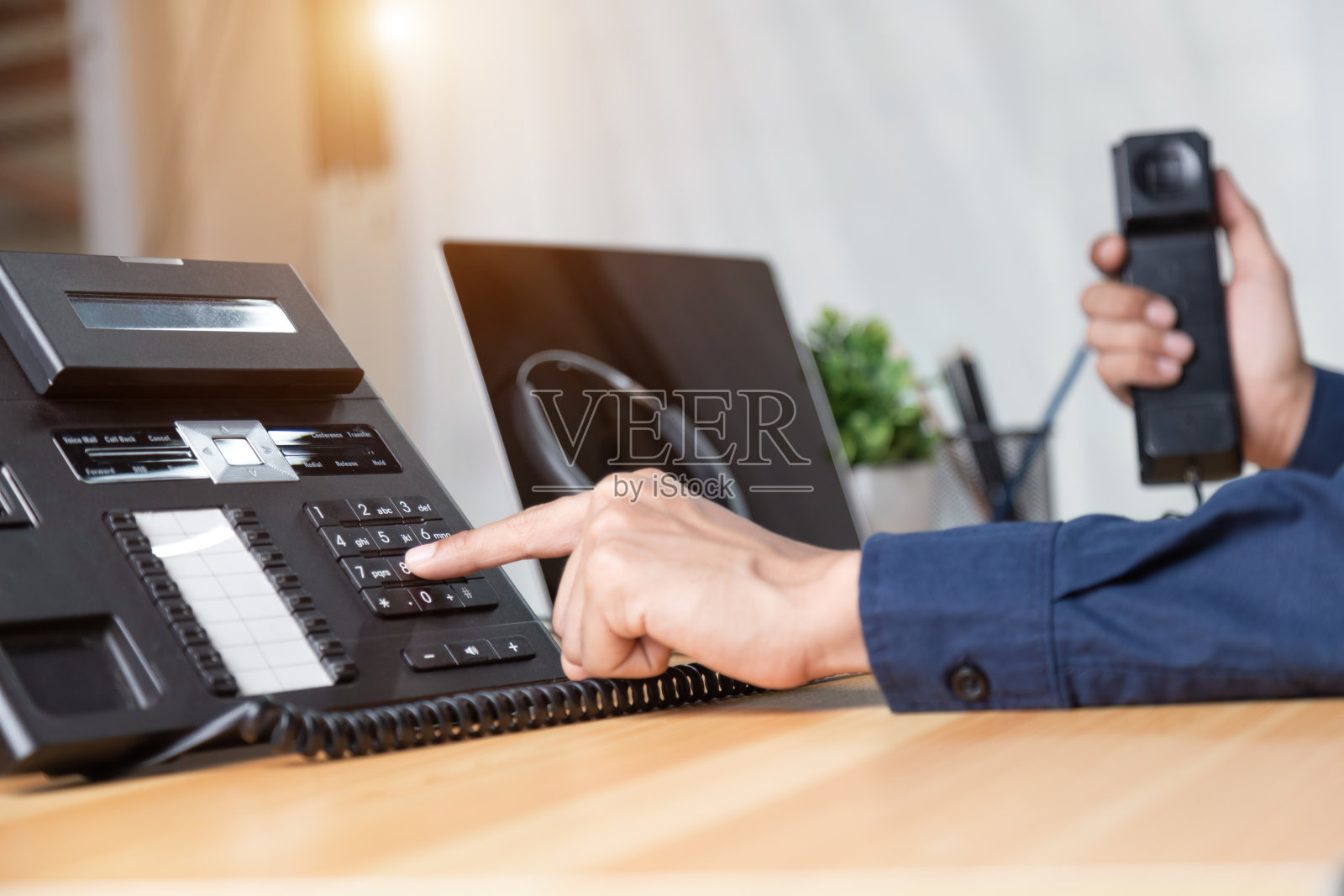呼叫中心工作人员手点按电话上的号码按钮，办公桌面、通信支持、呼叫中心和客户服务帮助台。For(呼叫中心)概念照片摄影图片