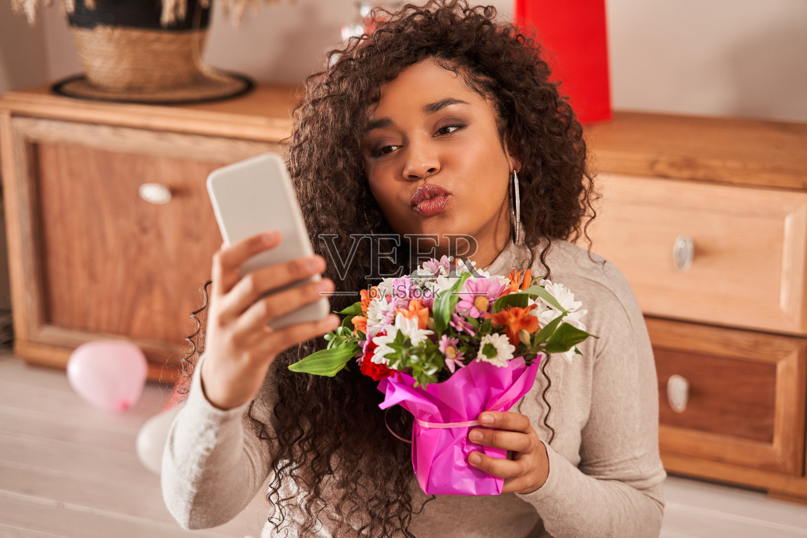 多种族女性用手机自拍，花就在脸上照片摄影图片