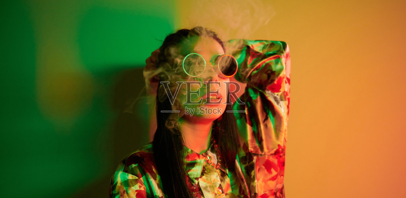 吸烟、活动。时尚的年轻女子站在工作室霓虹灯照片摄影图片