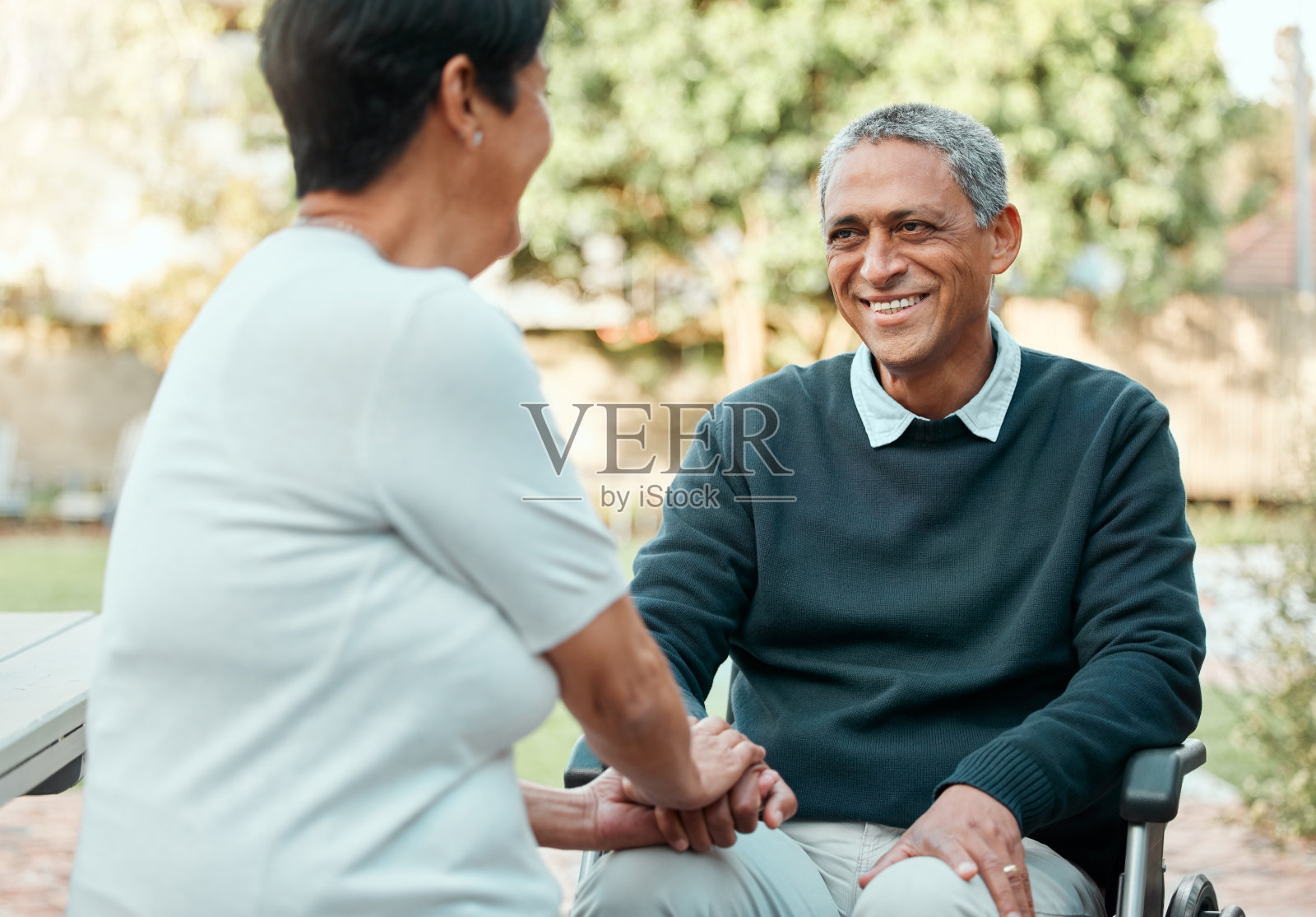 这张照片拍摄的是一对老夫妇坐在外面的花园中，深情相爱照片摄影图片