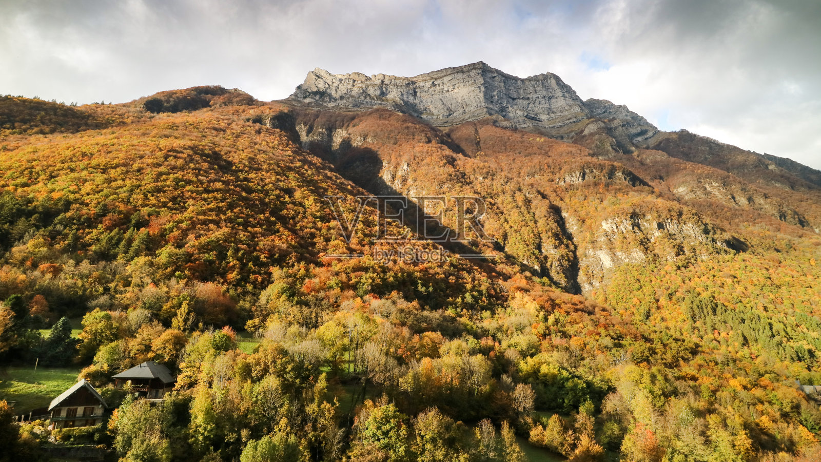 这是一幅风景，在秋天的时候，山岩和树木的金黄色照片摄影图片