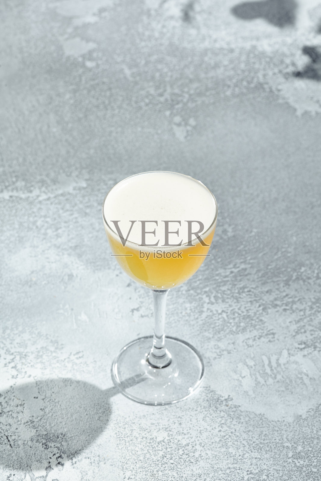 威士忌酸鸡尾酒是一种以威士忌为基酒，加入蛋白的鸡尾酒。有阳光和阴影的复古餐桌。烈性酒加威士忌、糖浆和柠檬汁。照片摄影图片