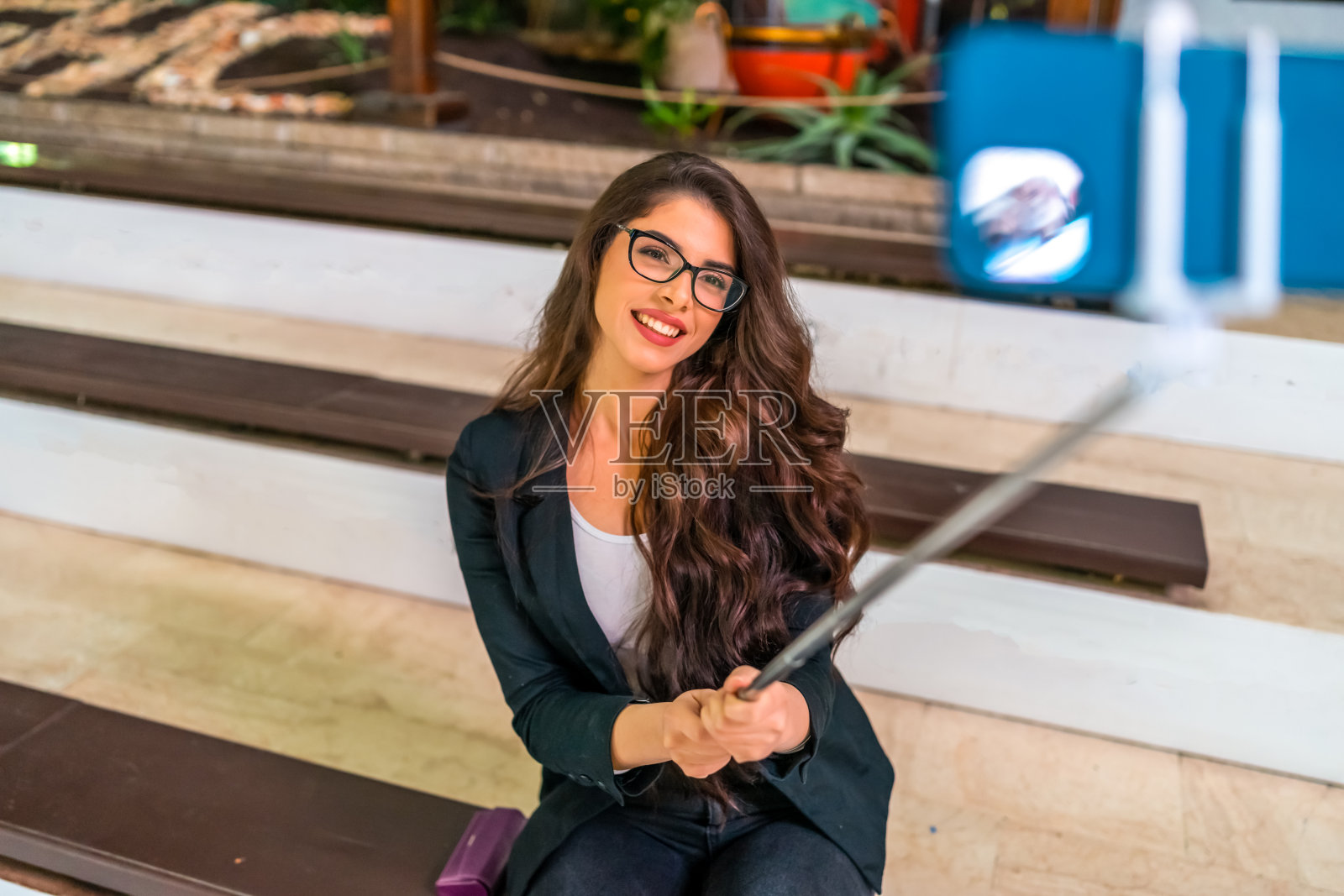 年轻美丽的商业女性使用她的手机贴自拍和视频电话与朋友照片摄影图片