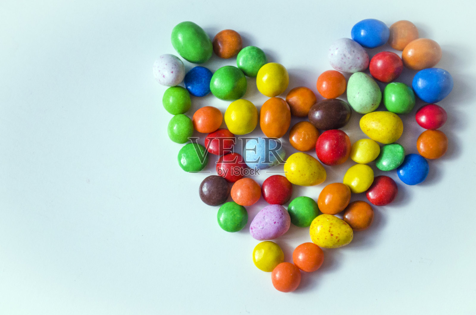 白色背景上心形形状的彩色小糖果照片摄影图片