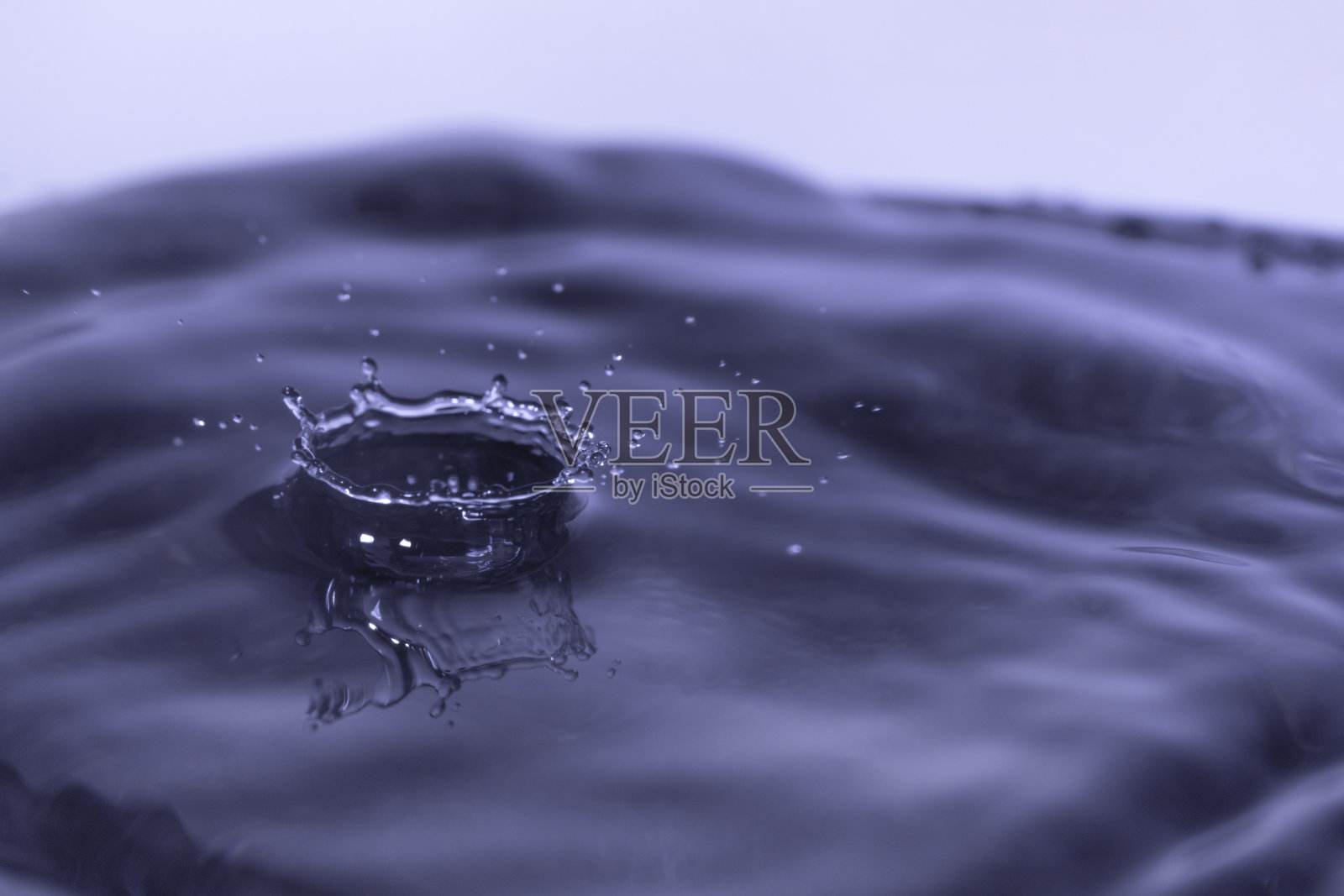 水滴和水花落在光滑潮湿的表面上。照片摄影图片