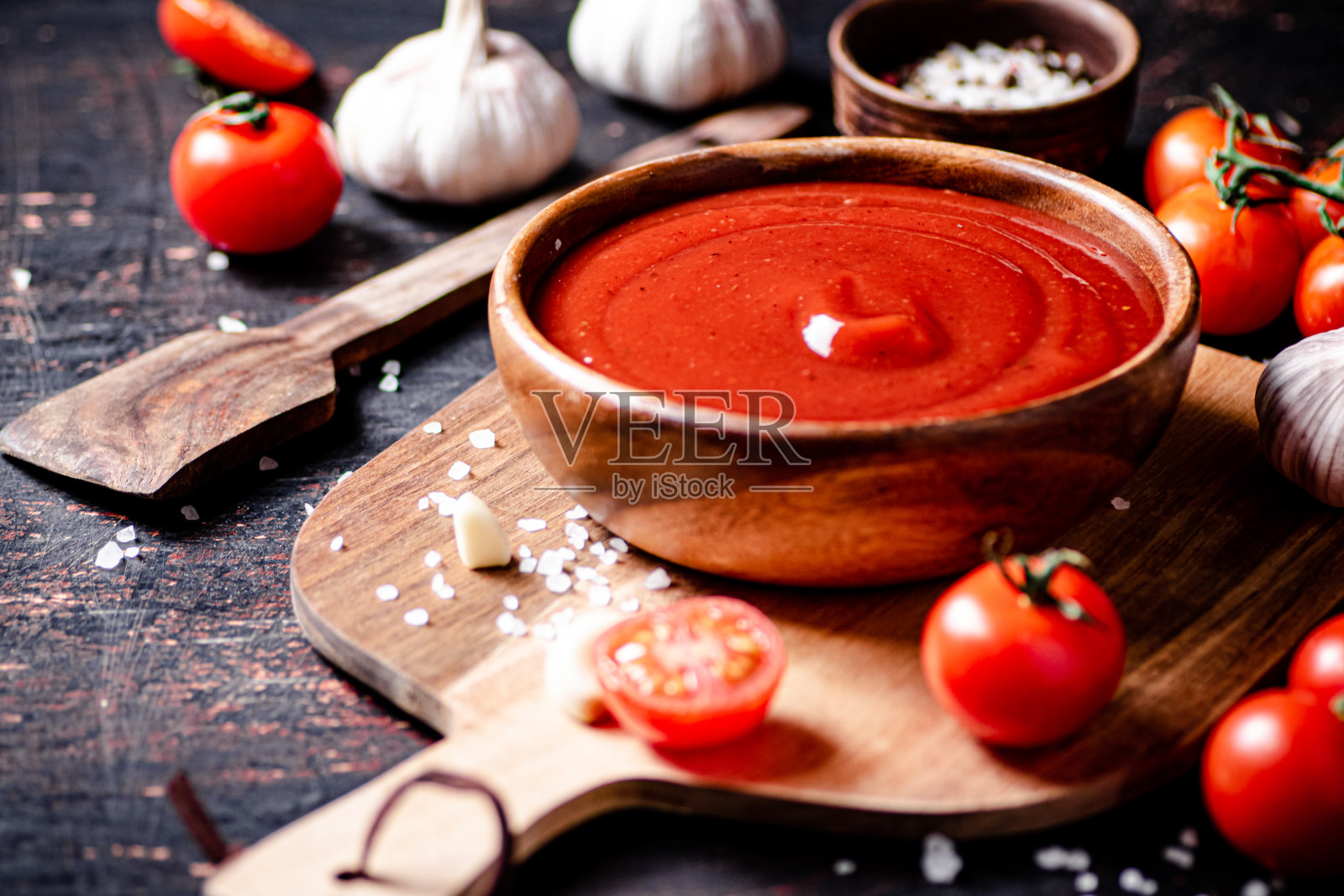 把番茄酱和大蒜和香料放在木板上。照片摄影图片