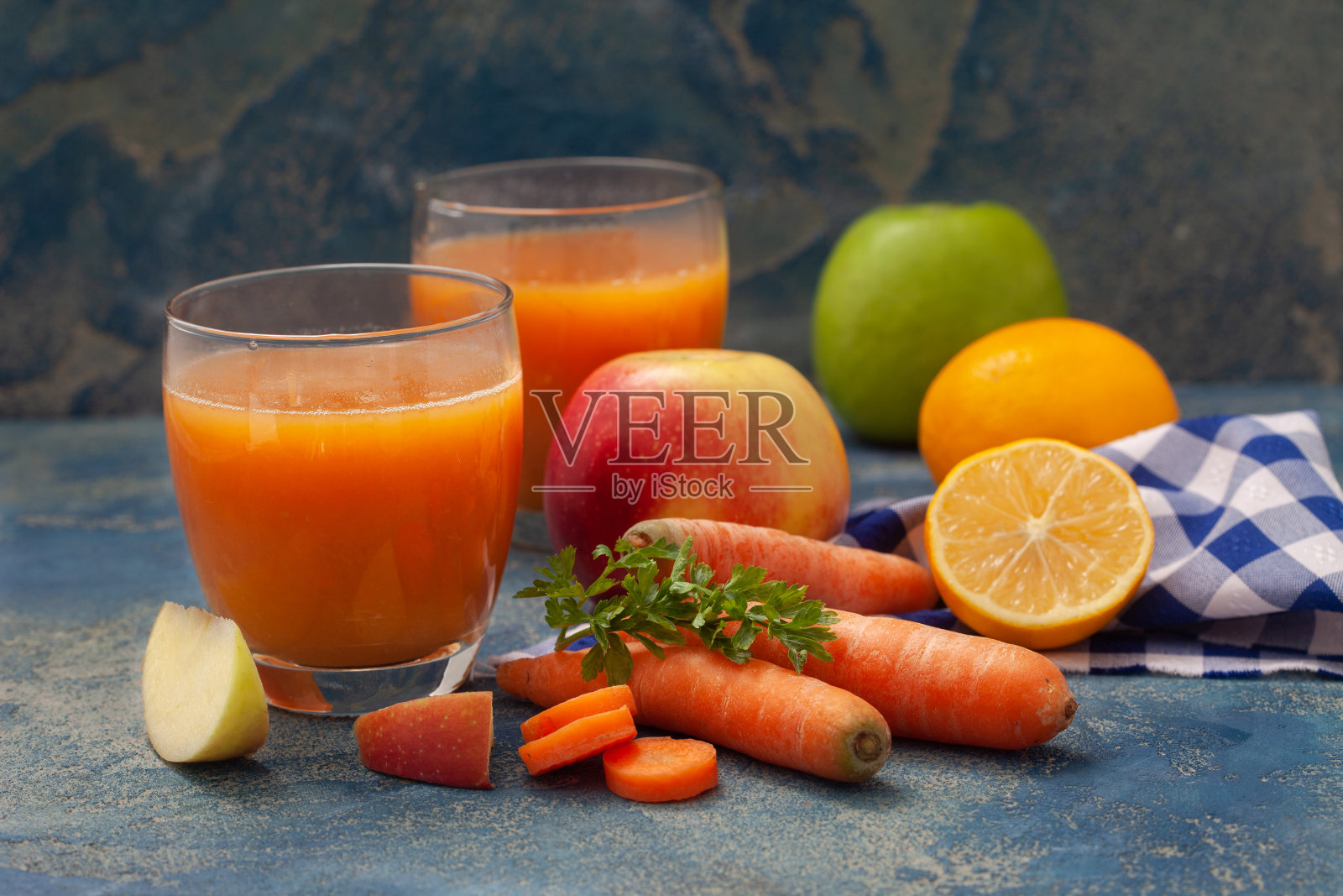 天然有机新鲜果汁由胡萝卜和苹果在蓝色的背景照片摄影图片