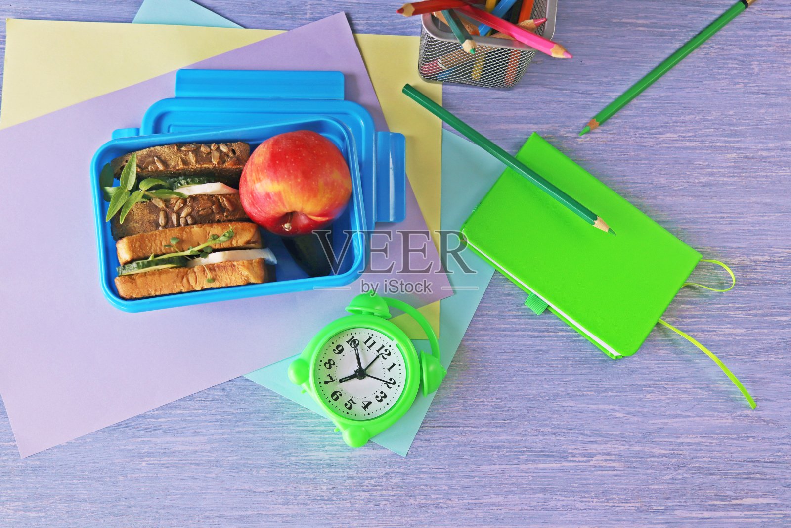午餐盒，麦片三明治，芝士，有机蔬菜和微绿色蔬菜，苹果，文具和闹钟照片摄影图片