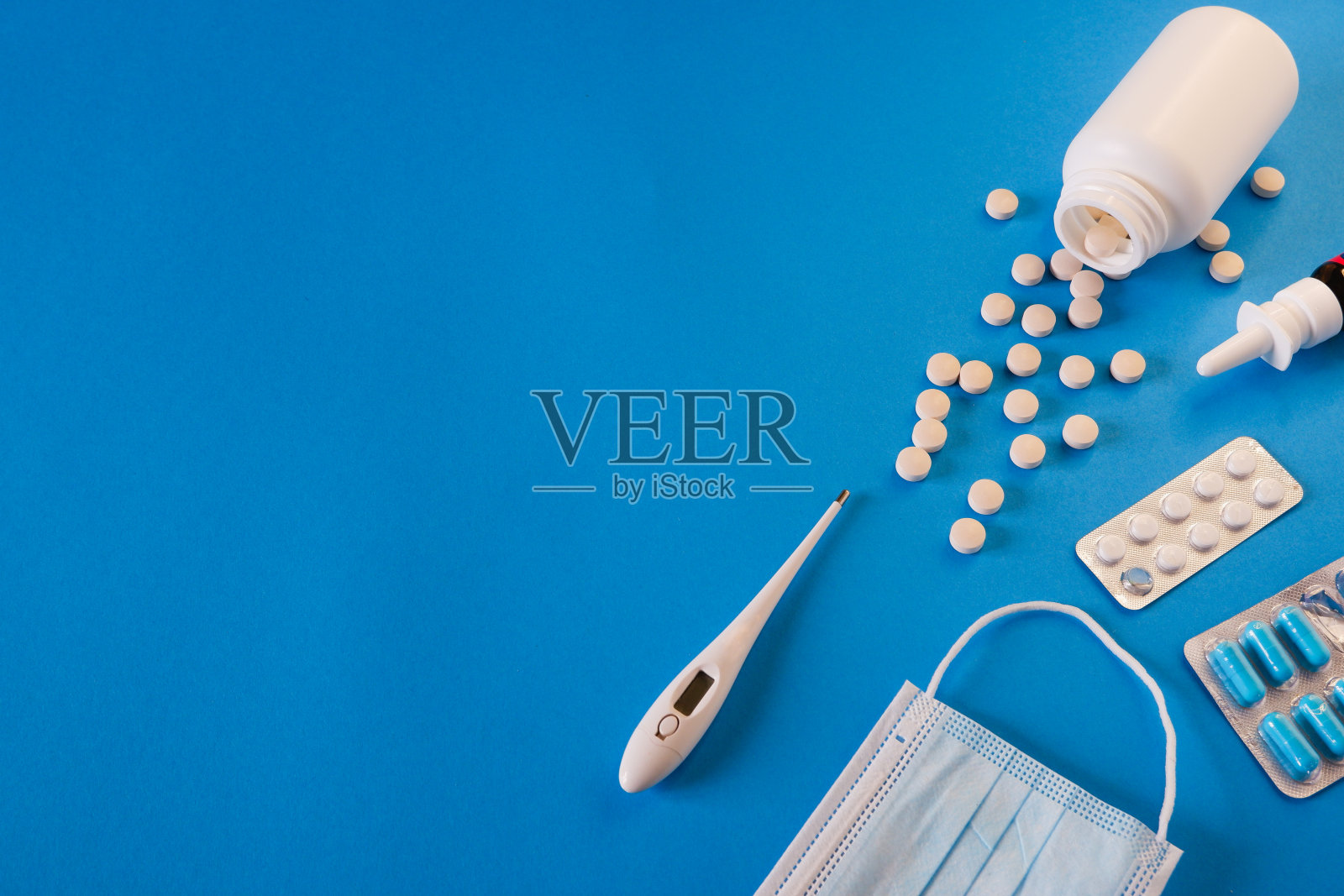 医学与健康观念。蓝色背景的药片，温度计和医用口罩。放置你的文本。照片摄影图片