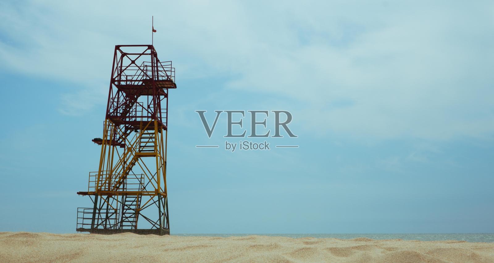 一座沙滩救援服务的金属瞭望塔，矗立在沙滩上，映衬着蓝天。照片摄影图片