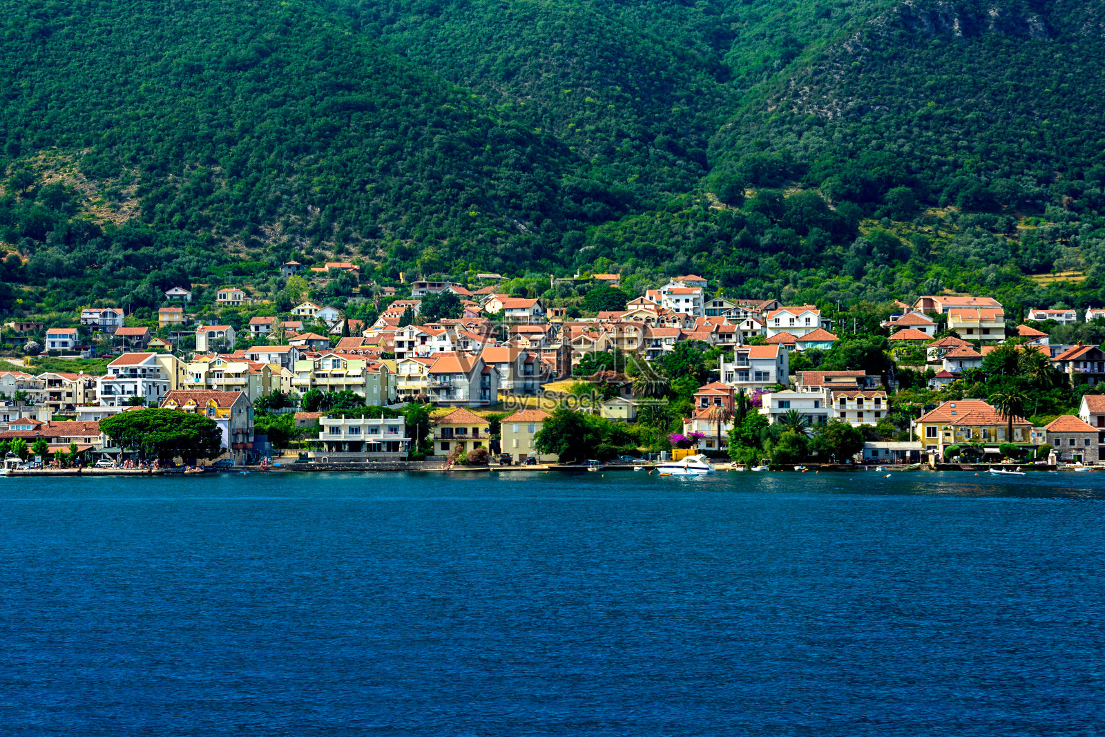 在群山的背景下，靠近海边的城市照片摄影图片