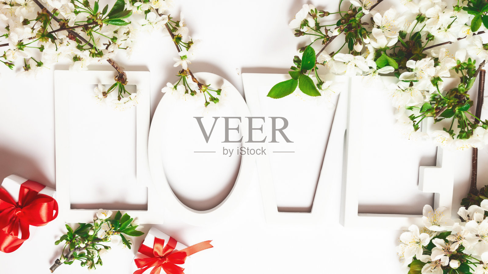 情人节礼物，白色背景上写着“爱”字。春天的花朵照片摄影图片