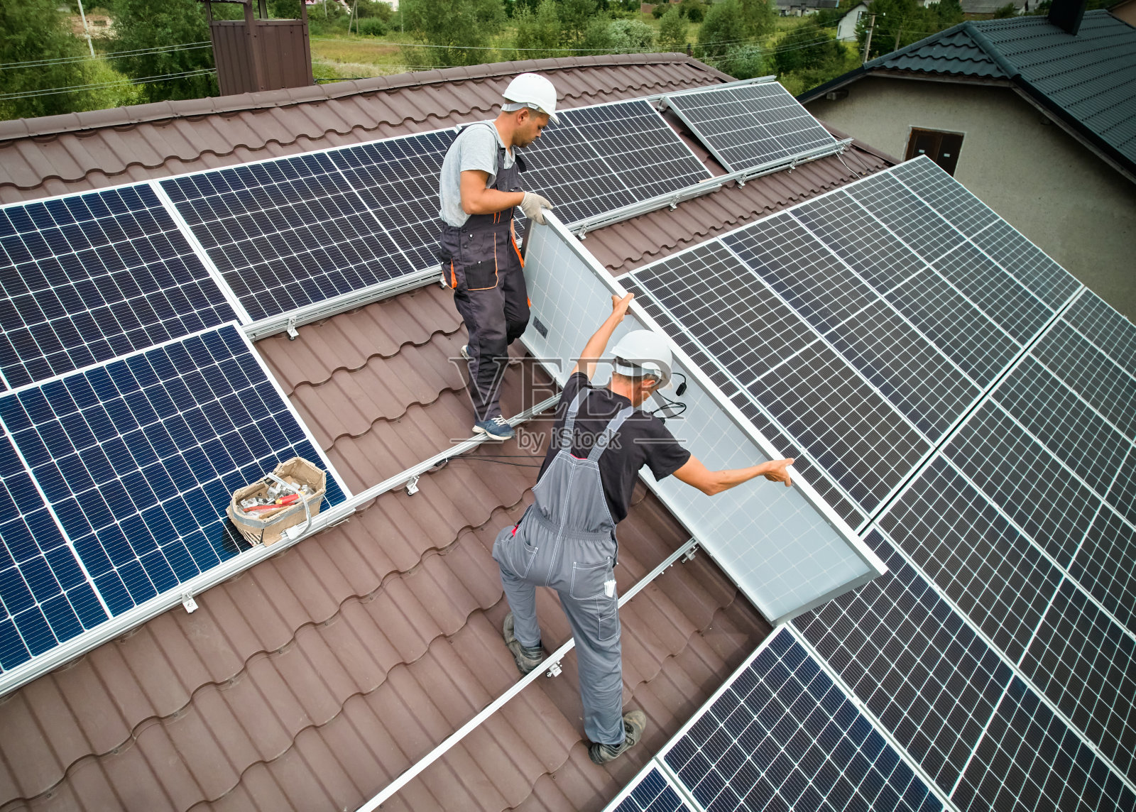 带领技术员在屋顶安装光伏太阳能组件。照片摄影图片