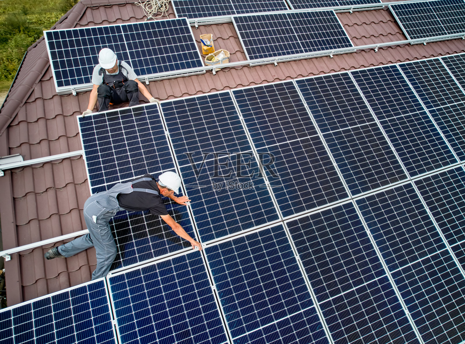 带领技术员在屋顶安装光伏太阳能组件。照片摄影图片