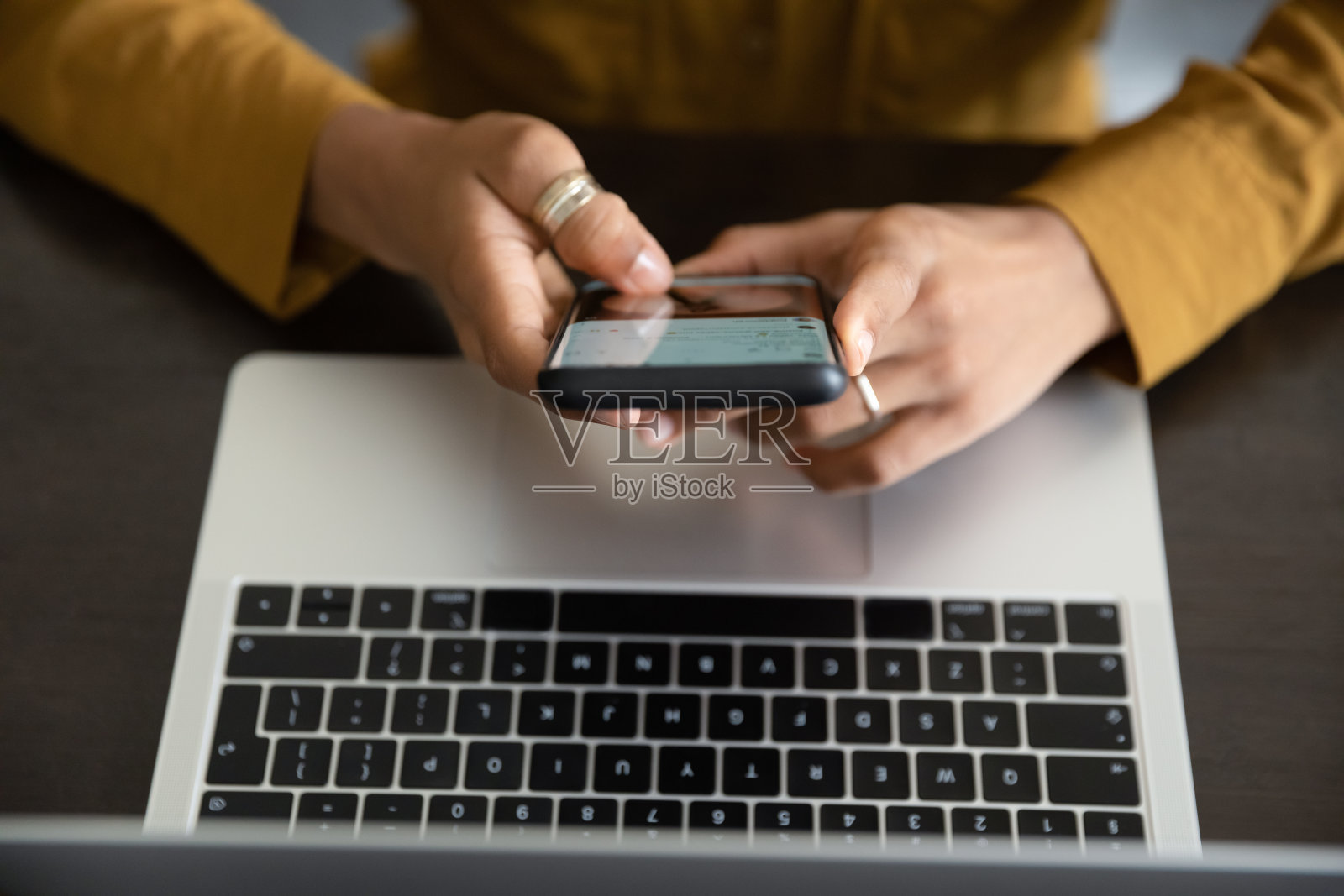 上面的俯视图年轻女子使用手机。照片摄影图片