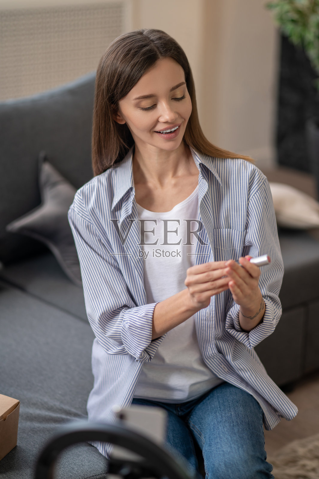 漂亮的美容教练在网上展示一款新的睫毛膏照片摄影图片