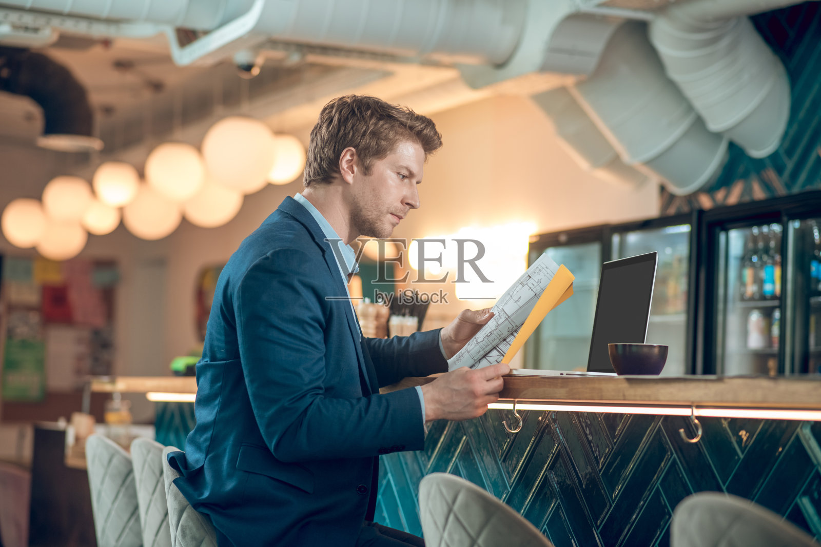 一名男子在咖啡馆里对着摄像机看文件照片摄影图片