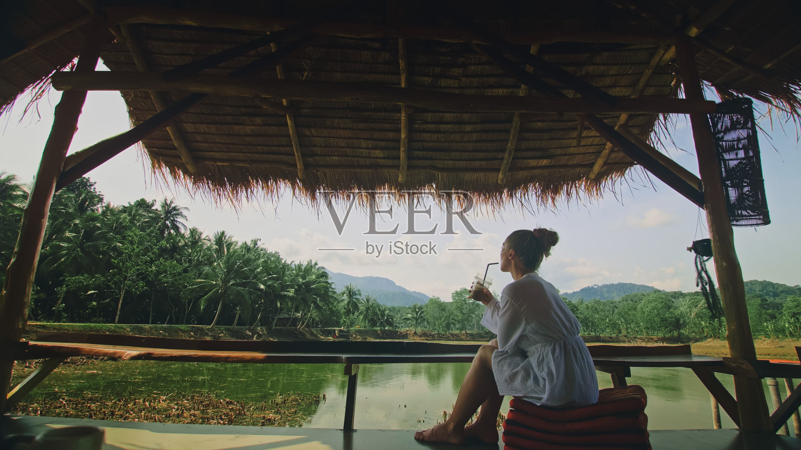 女人喝着鸡尾酒可口的饮料，冰咖啡。旅行者年代照片摄影图片