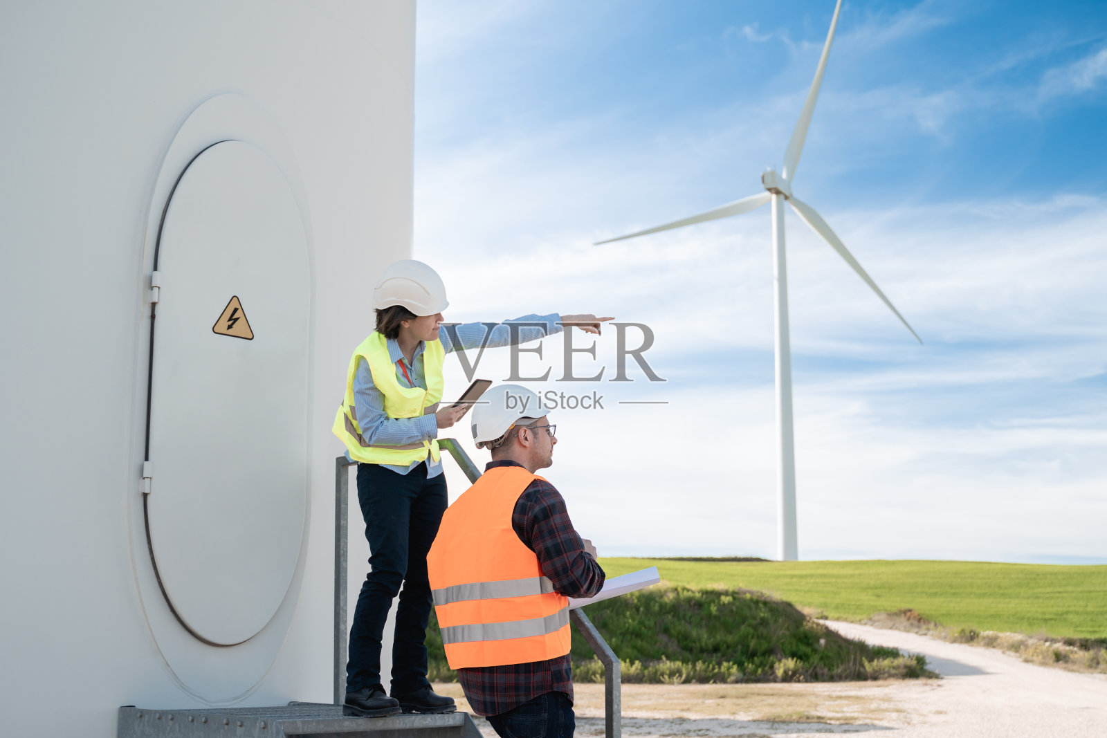 绿色能源-工程师的工作在可持续替代农场与涡轮机的背景-关注女性工人的脸照片摄影图片