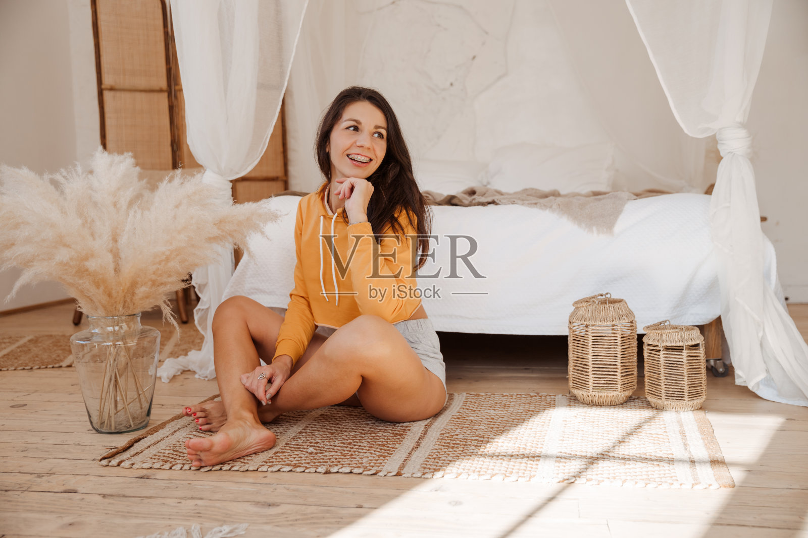 微笑的女人醒来后，健康的睡眠，坐在舒适的卧室享受早上好照片摄影图片