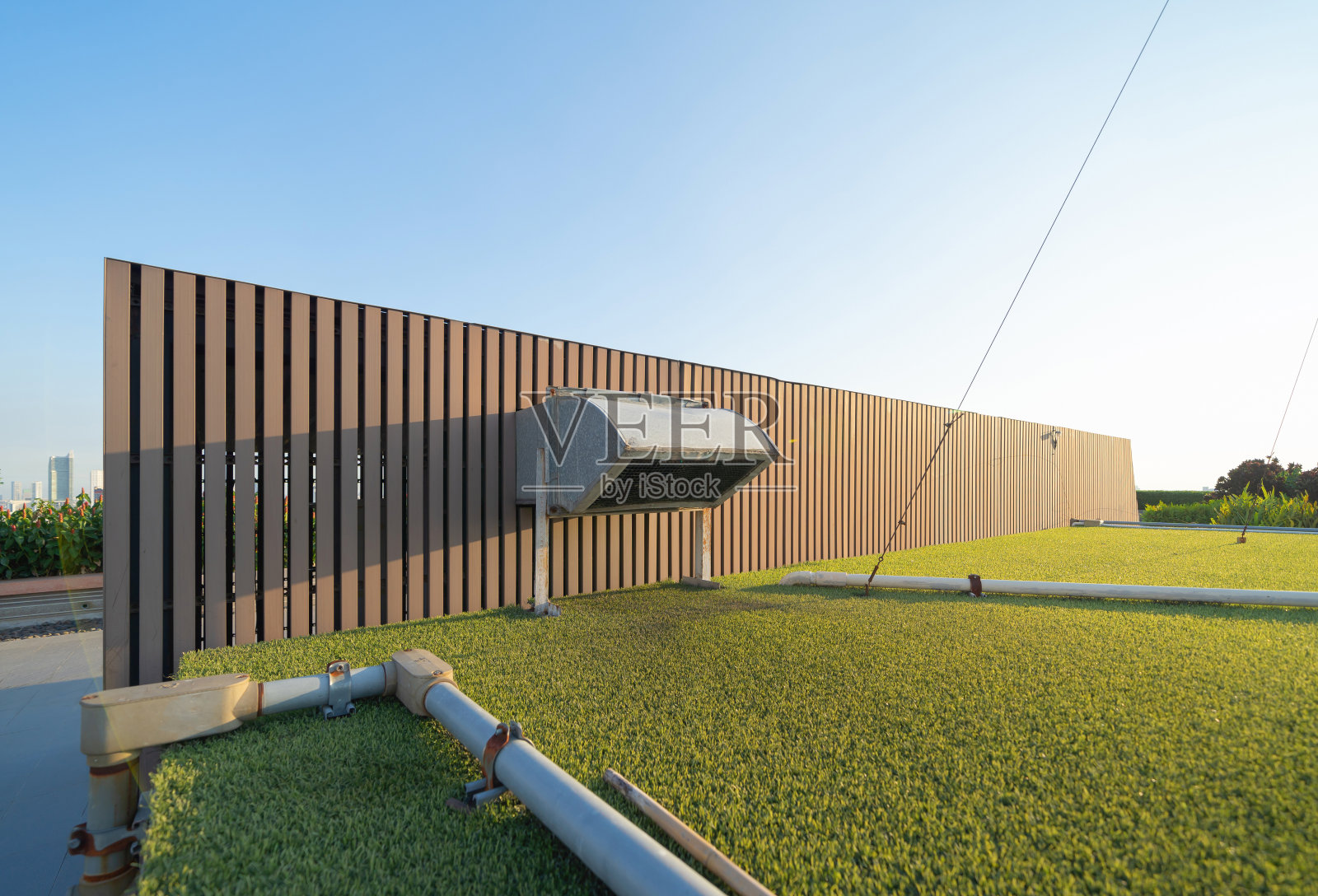 办公楼屋顶的冷却塔或冷却塔管道与城市的天际线屋顶上的城市。系统的工作。建筑机器。管道。通风式压缩机照片摄影图片