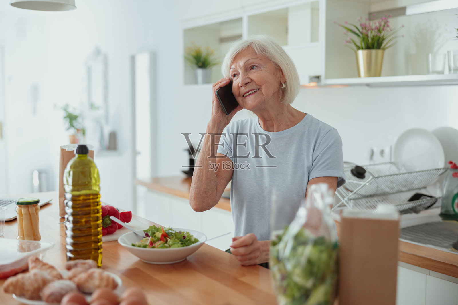 退休妇女在舒适的家庭厨房交流照片摄影图片