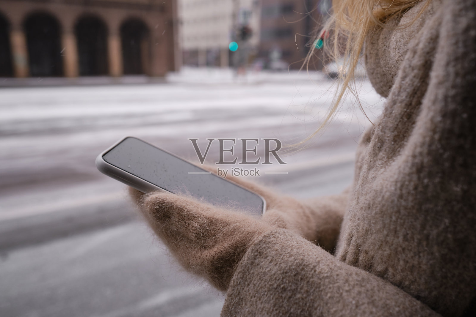 一名女子手持一部现代智能手机，正在发短信或使用手机应用程序。互联网技术的用户。智能手机的特写。专注于手机屏幕照片摄影图片