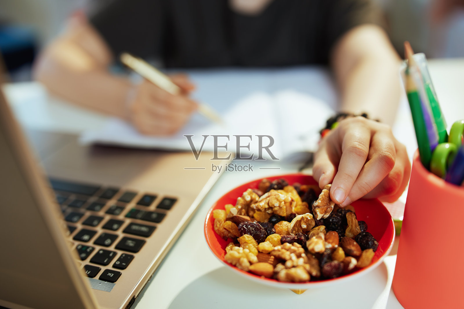 现代学生接受在线教育，吃健康的零食照片摄影图片