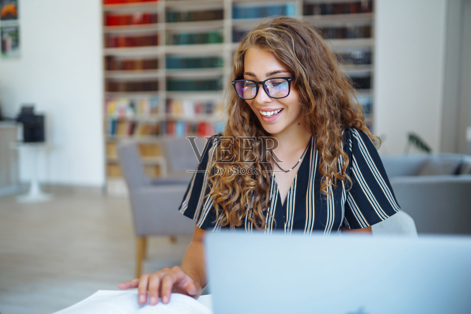 年轻女性在家里用笔记本电脑工作。照片摄影图片