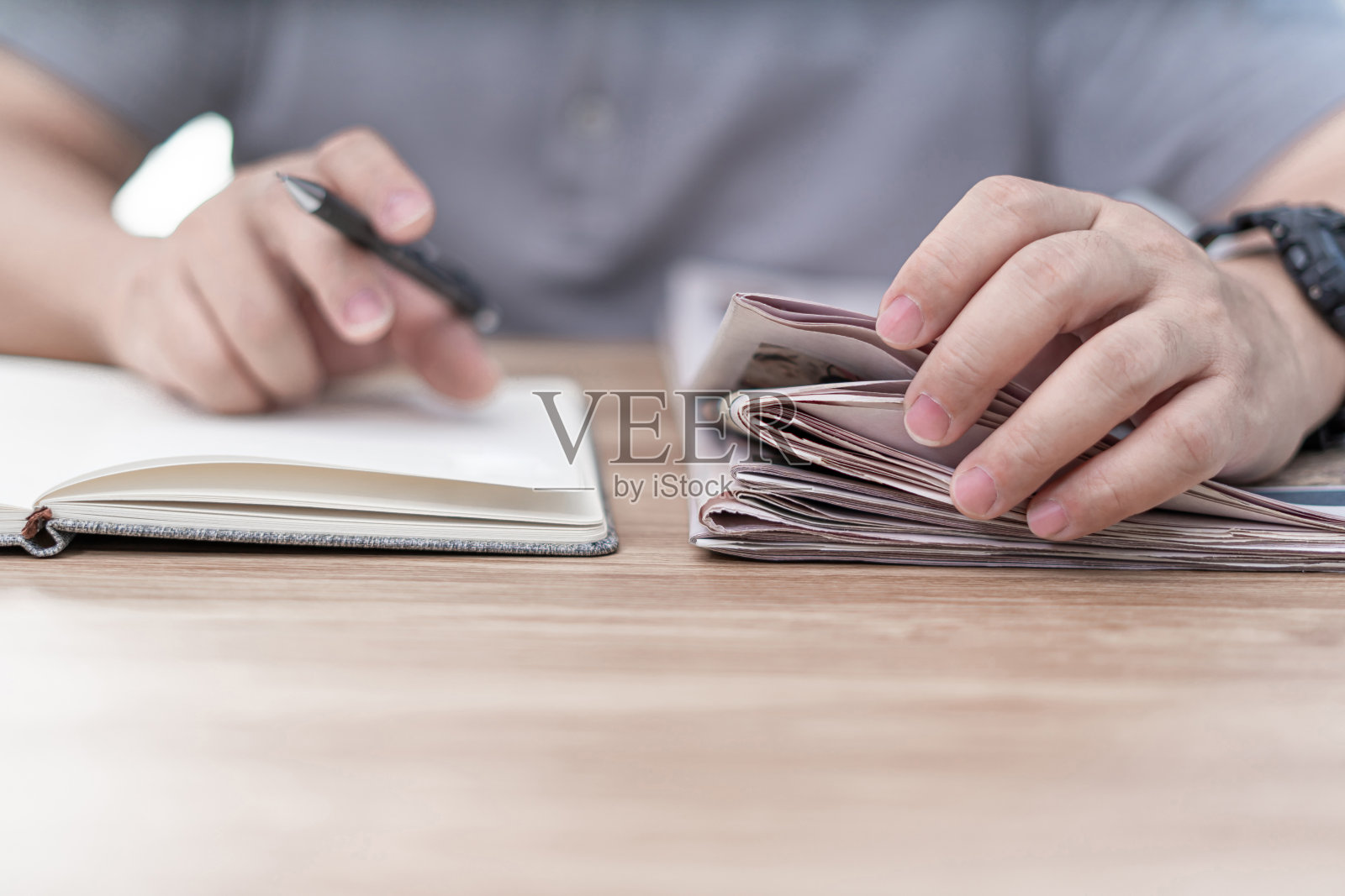 一个男人用手合上报纸，在书上写着:阅读日报上的信息照片摄影图片