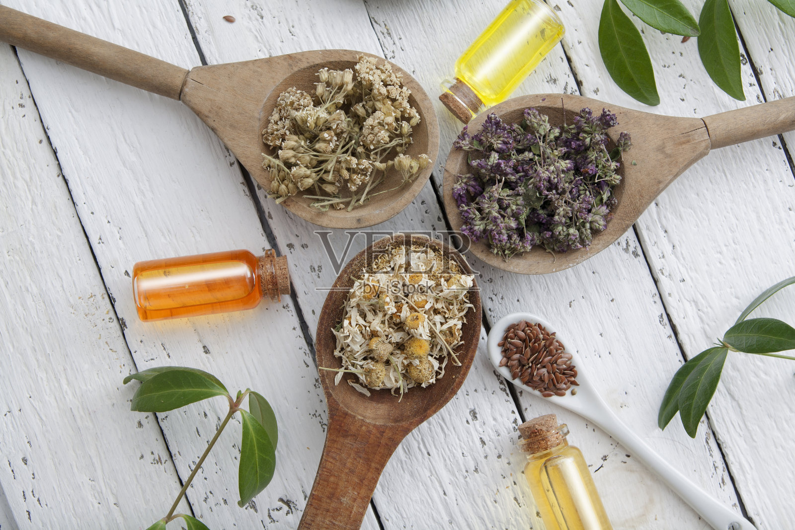 白色木桌上放着干燥的草药和香精。替代医学。平躺照片摄影图片