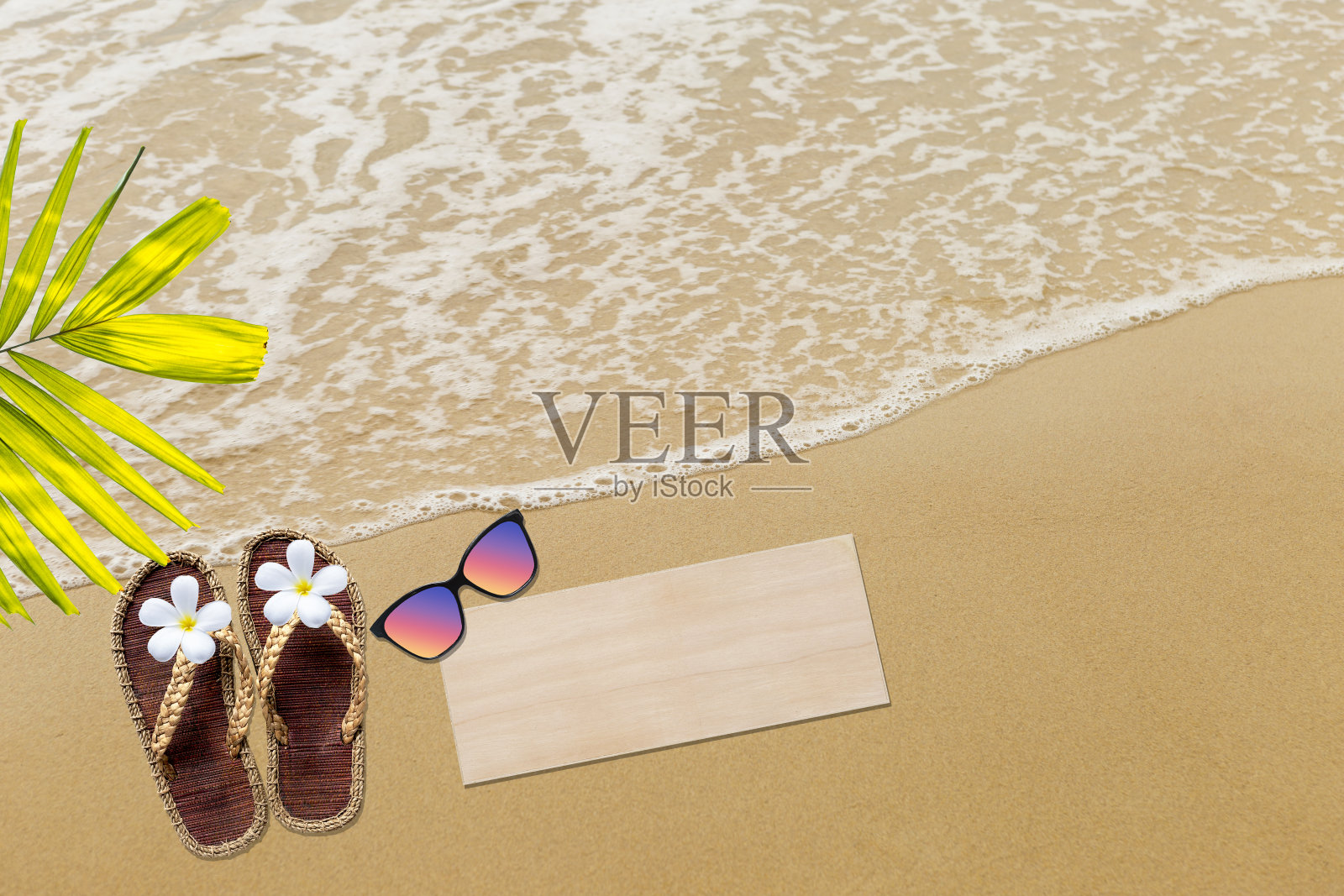 黄麻凉鞋，戴着太阳镜，沙滩上的空白木制标牌照片摄影图片