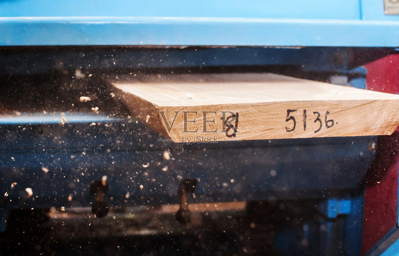 在木工车间用厚度计工作。平刨木头照片摄影图片