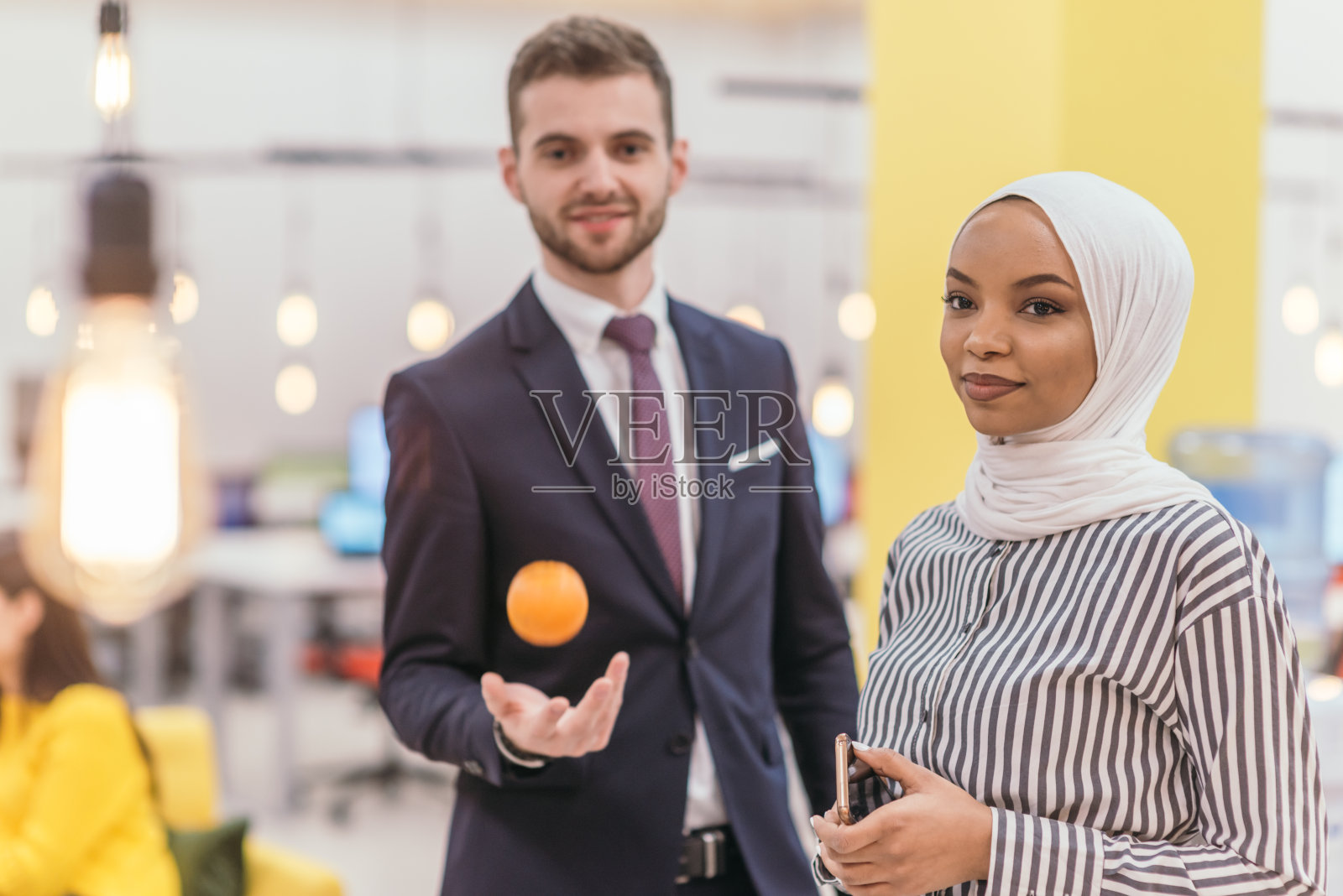 一名穆斯林非裔美国女商人的肖像，站在一个现代办公室的中间工作。照片摄影图片