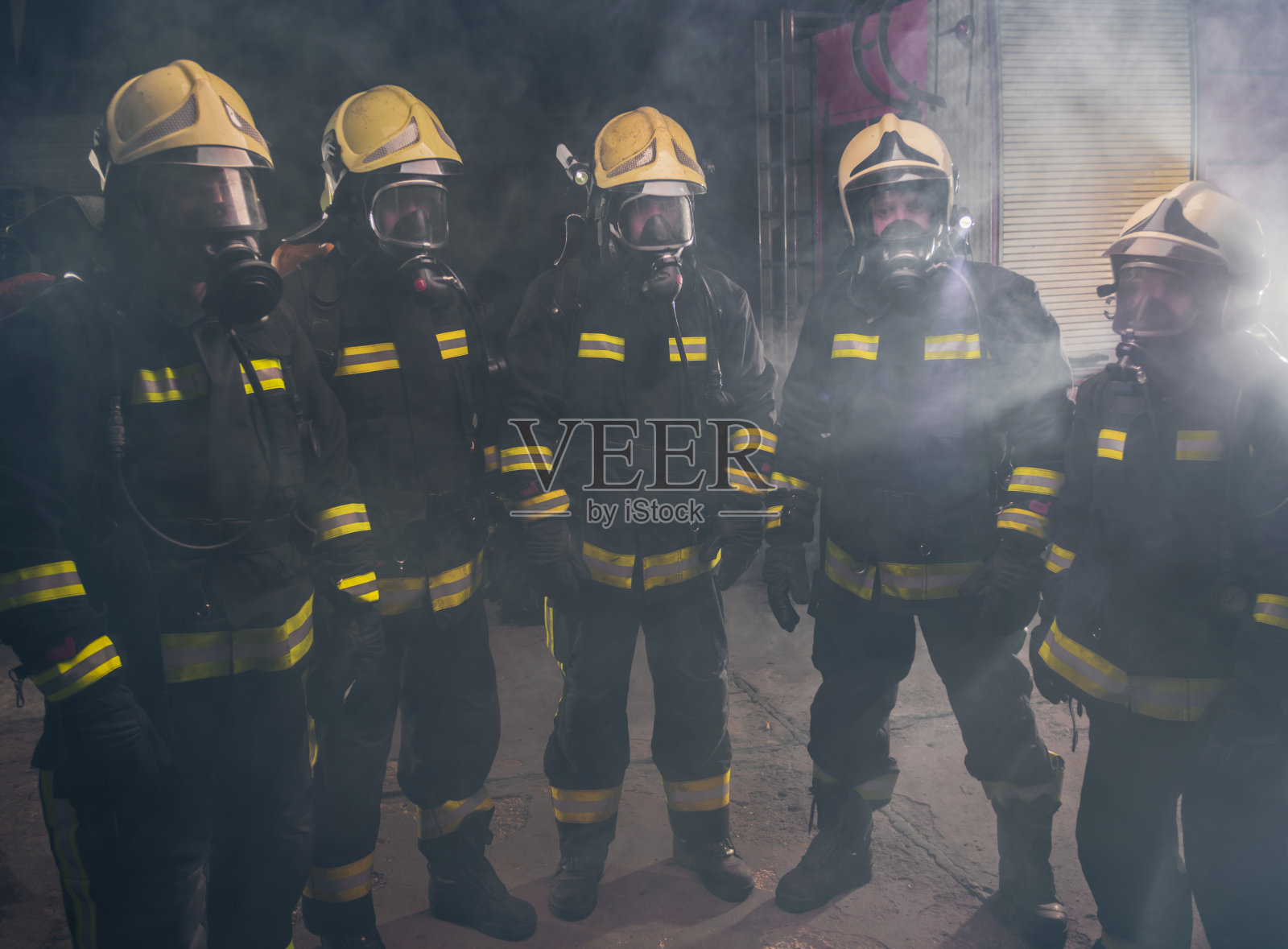 图为一群消防员在灭火器的烟雾中照片摄影图片