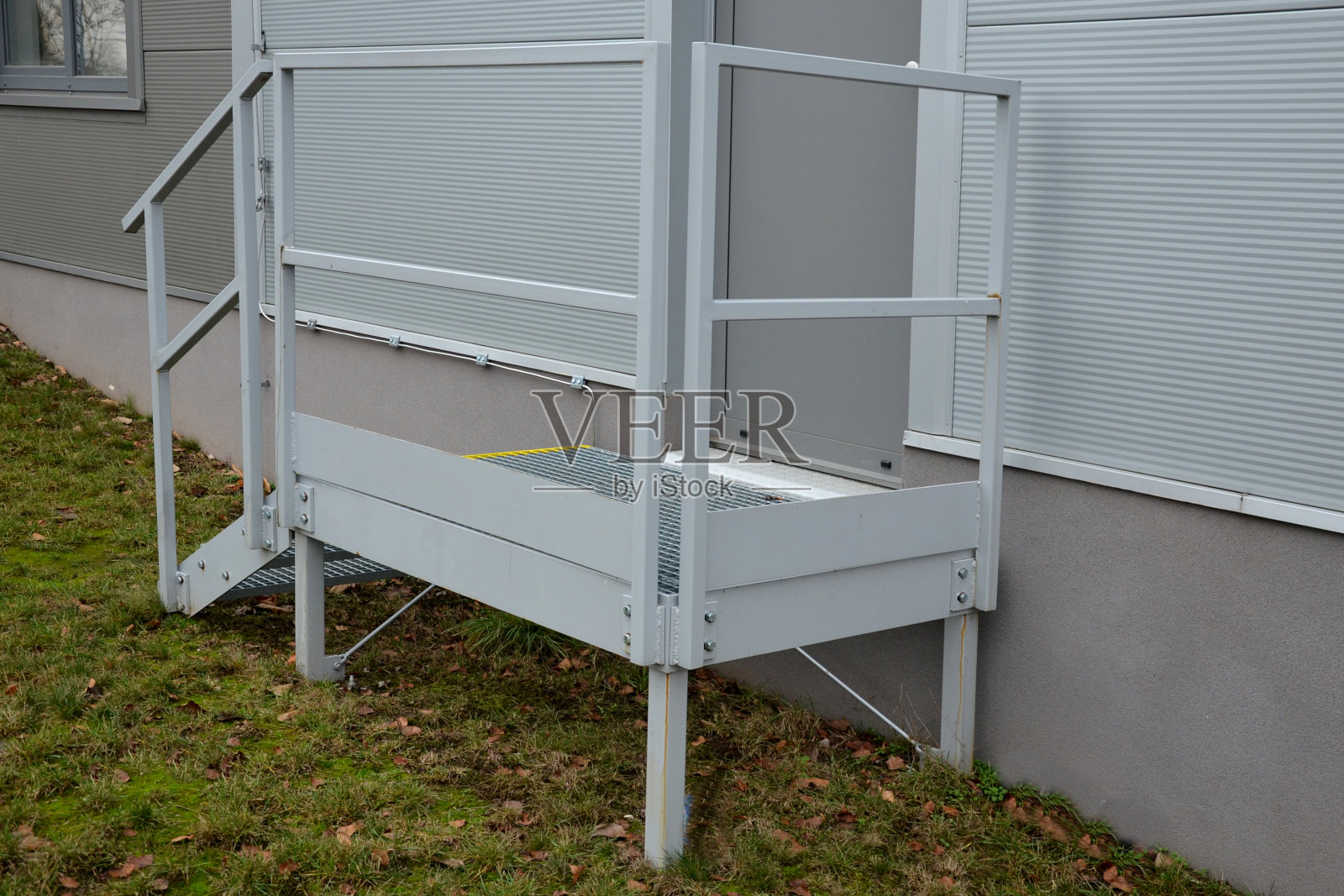 工业大厅、仓库在陡峭的楼梯上有一个侧门，即使在重负荷镀锌钢地板格栅和栏杆下也有很高的阻力。膨胀金属，楼梯边缘安全黄色照片摄影图片