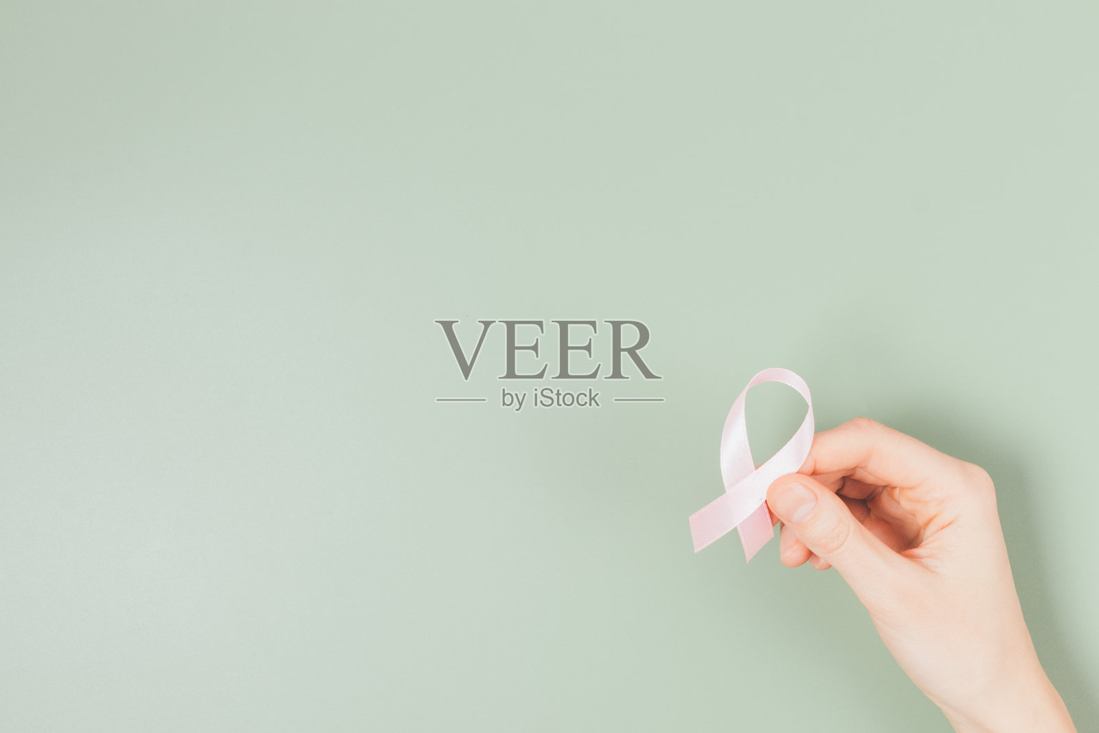 近距离的女性手握粉红色的世界癌症日丝带照片摄影图片