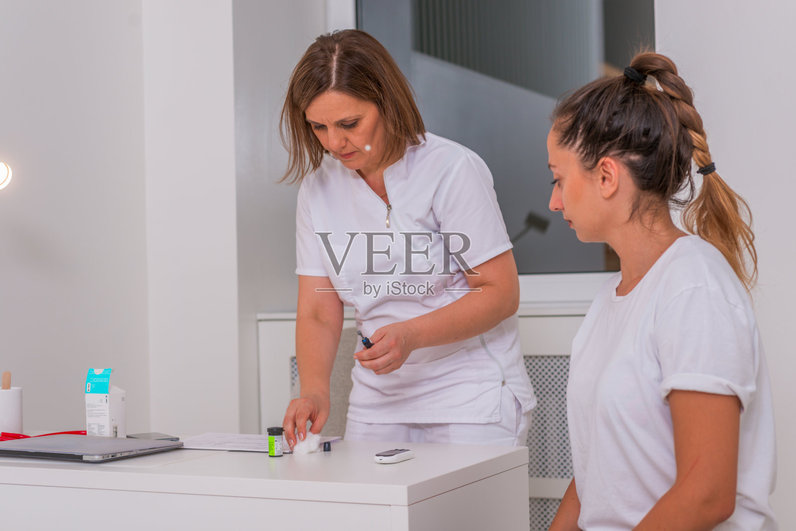 医生用血糖仪检查女孩的血糖水平。照片摄影图片