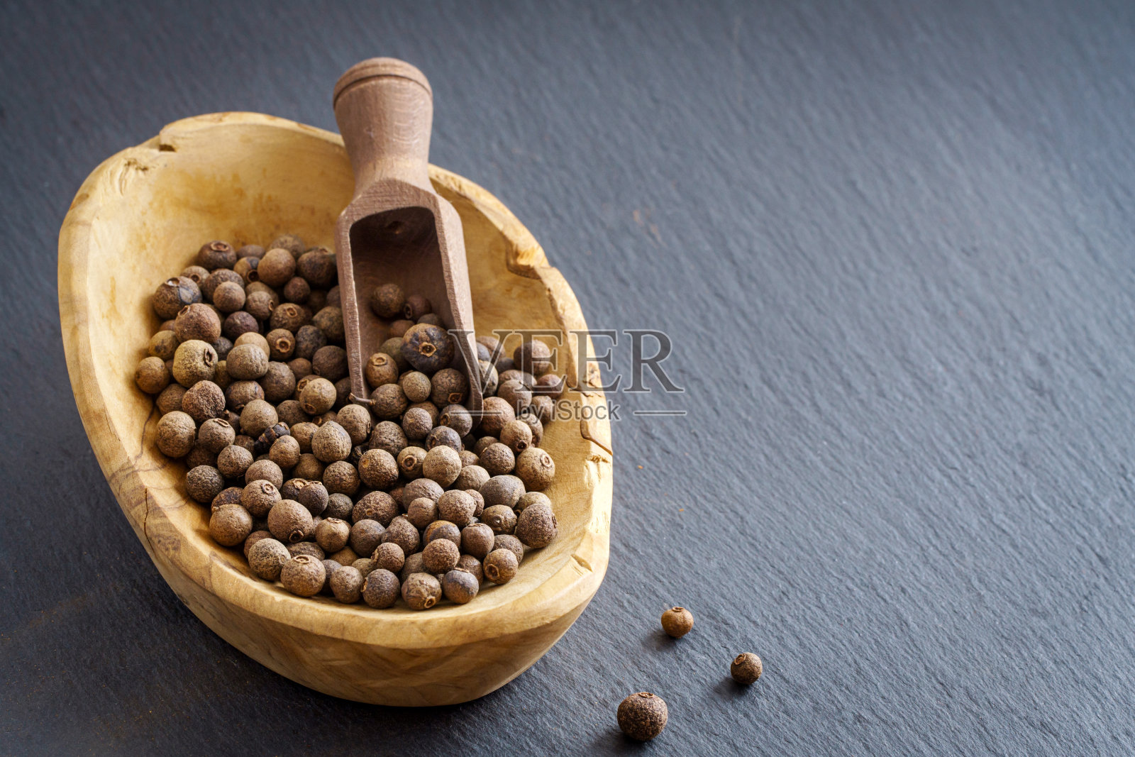 多香果在木碗勺子石板与复制空间照片摄影图片