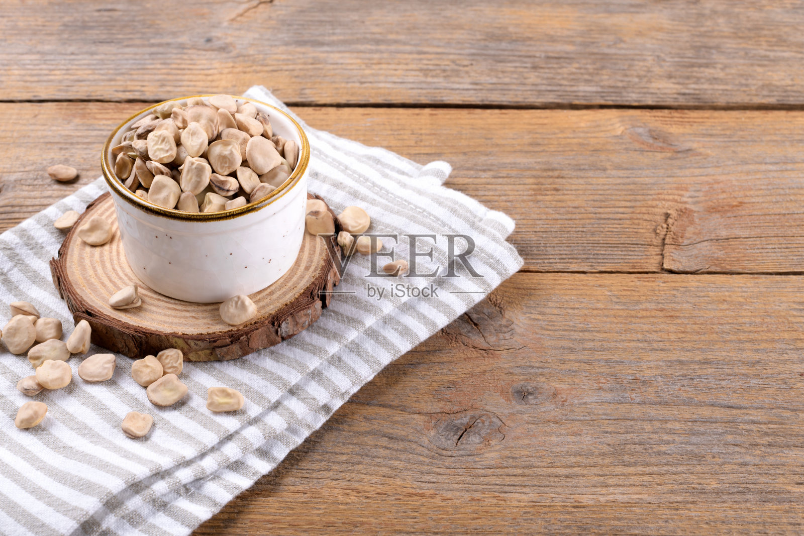 在陶瓷碗上放干燥的生西芹或印度豌豆，在木制的背景上铺上餐巾，复制空间照片摄影图片