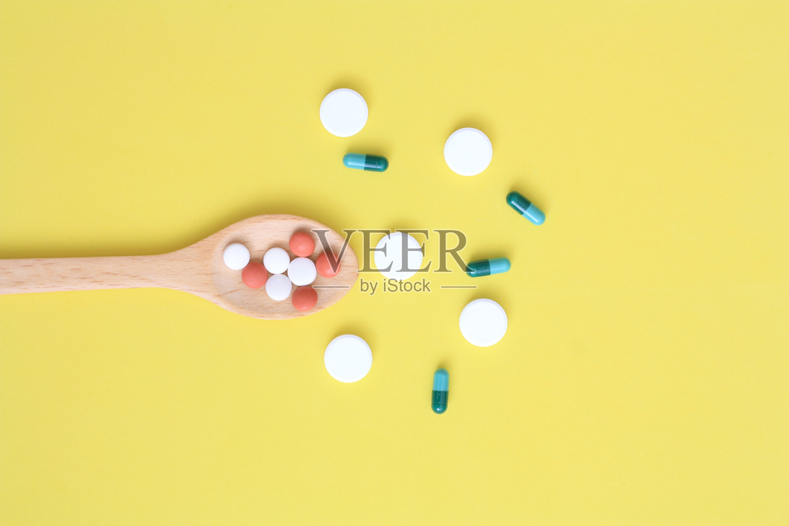 木勺上有彩色胶囊照片摄影图片