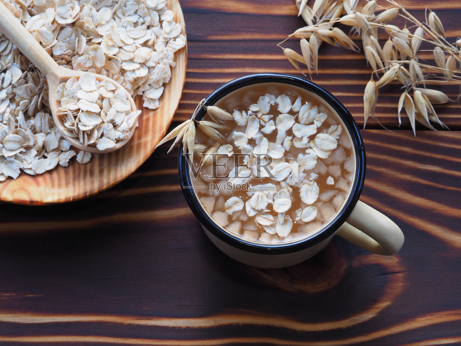 天然有用的燕麦饮料在一个杯子，燕麦片在勺子和小穗燕麦sativa谷草在木制背景，俯视图。健康饮食的谷物燕麦营养照片摄影图片