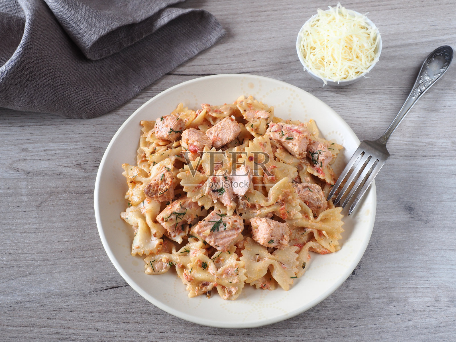 意大利面，三文鱼，奶油酱，帕玛森干酪，放在盘子里，餐巾纸，叉子放在轻的桌子上，平面布局。传统美味佳肴，搭配卷面和海鲜照片摄影图片