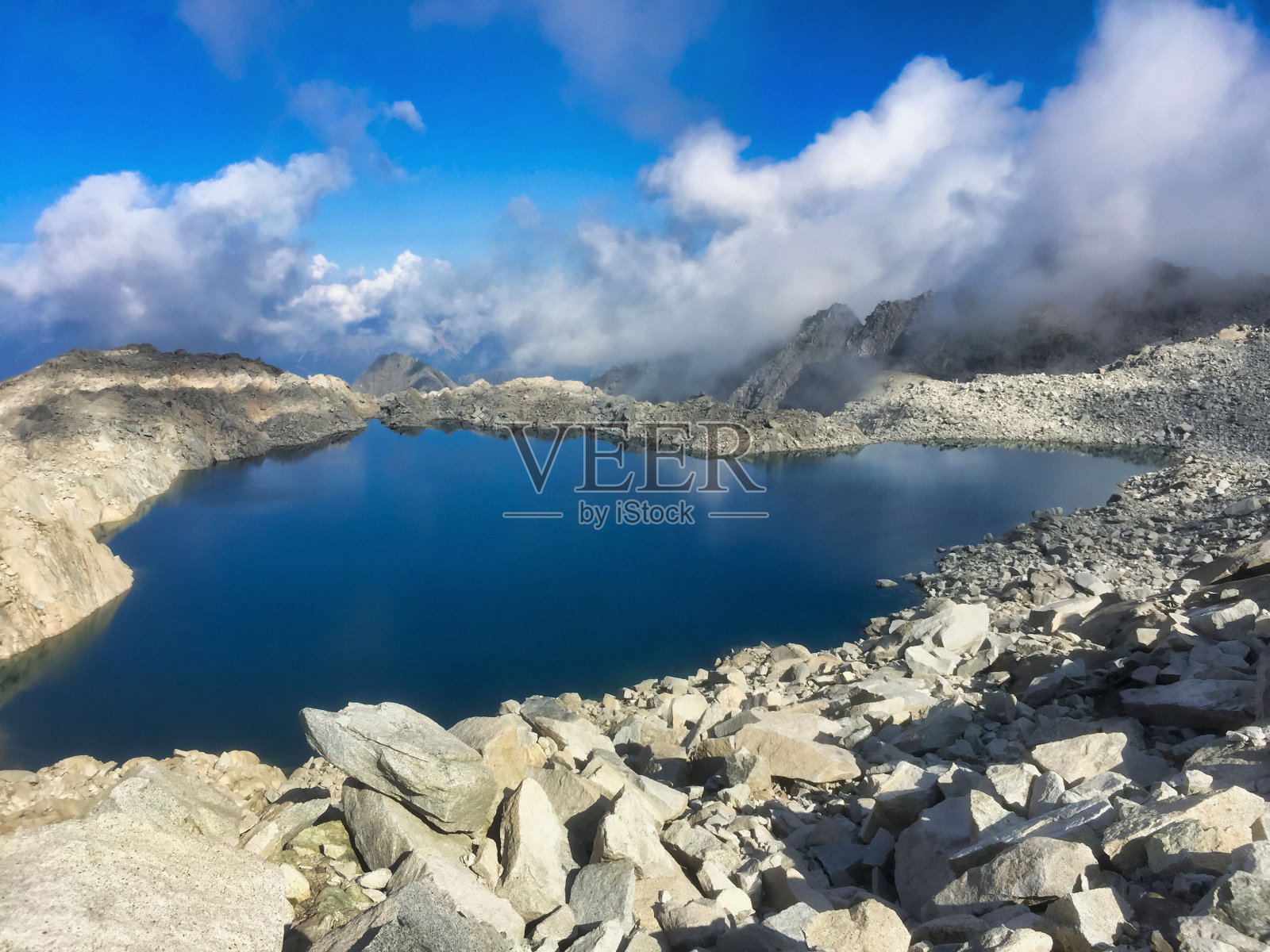 冰川上岩石间的小湖照片摄影图片