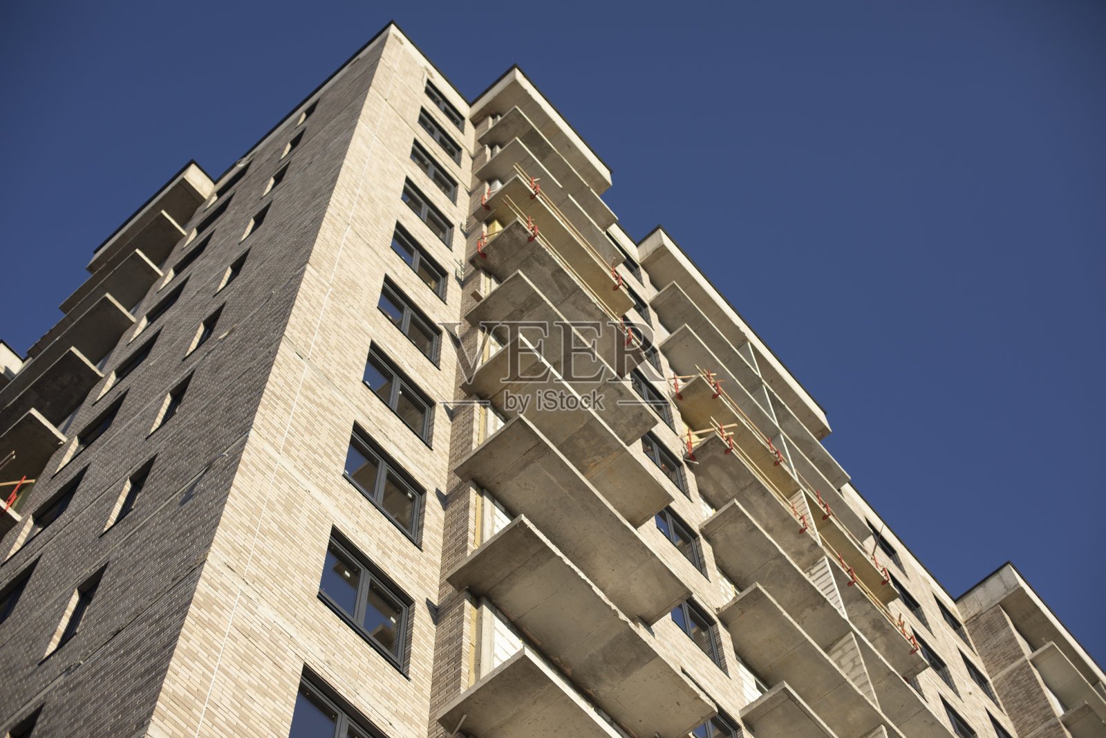 外观的建筑。未完成的房子。新建多层建筑的窗户。街上的塑料窗户。照片摄影图片