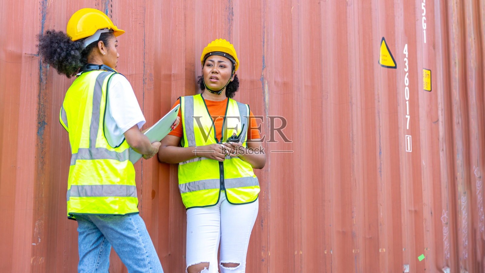 两个非洲姐妹拿着集装箱照片摄影图片